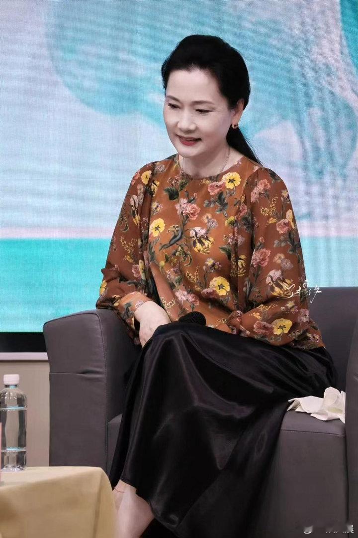 何赛飞的中老年穿搭品味绝佳，棕色印花上衣搭配缎面长裙，优雅贵气，时髦感拉满。