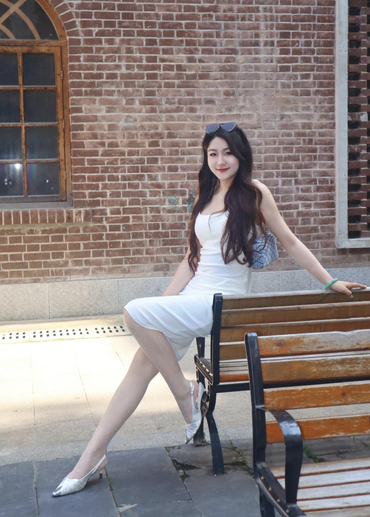 夏日清新穿搭，白色连衣裙搭配高跟鞋，坐在木椅上，阳光洒落，轻松自在。