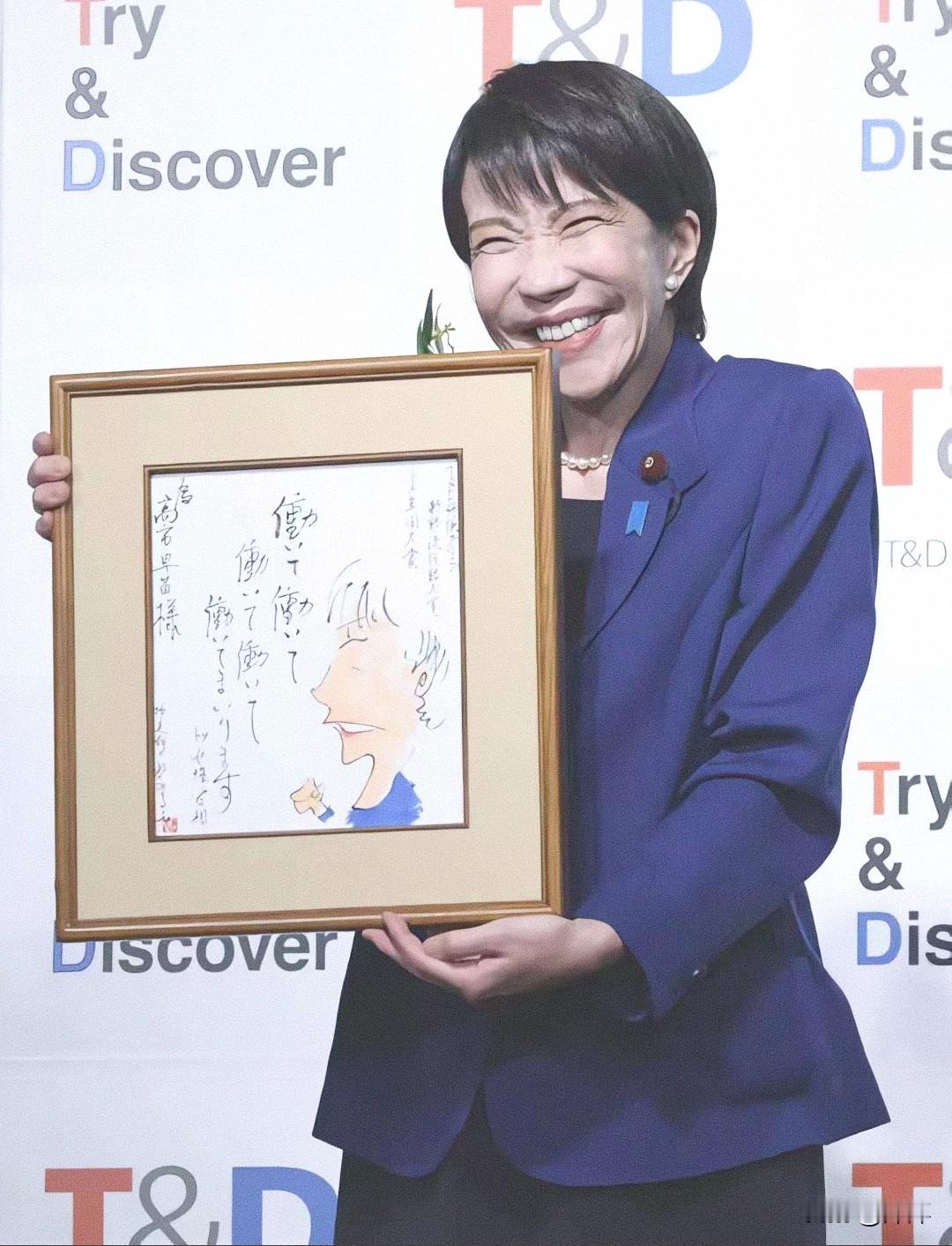 高市早苗手捧他人为她创作的肖像漫画，看把她高兴的样子好开心！