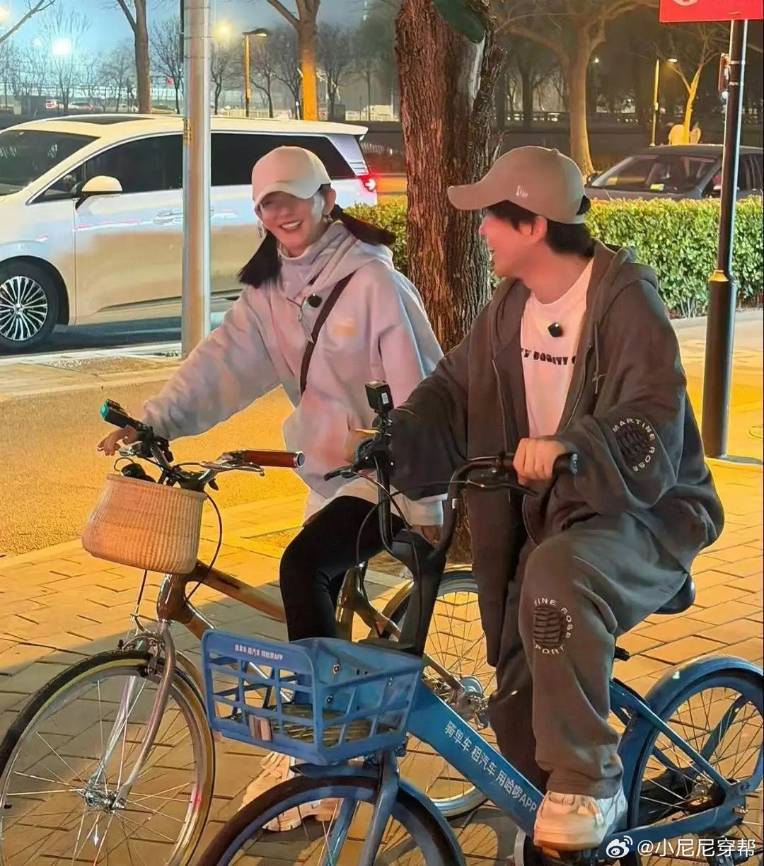 谢娜和好友沈凌在北京晚上骑自行车外出。她扎着两条马尾，个子矮小，看起来挺年轻的，