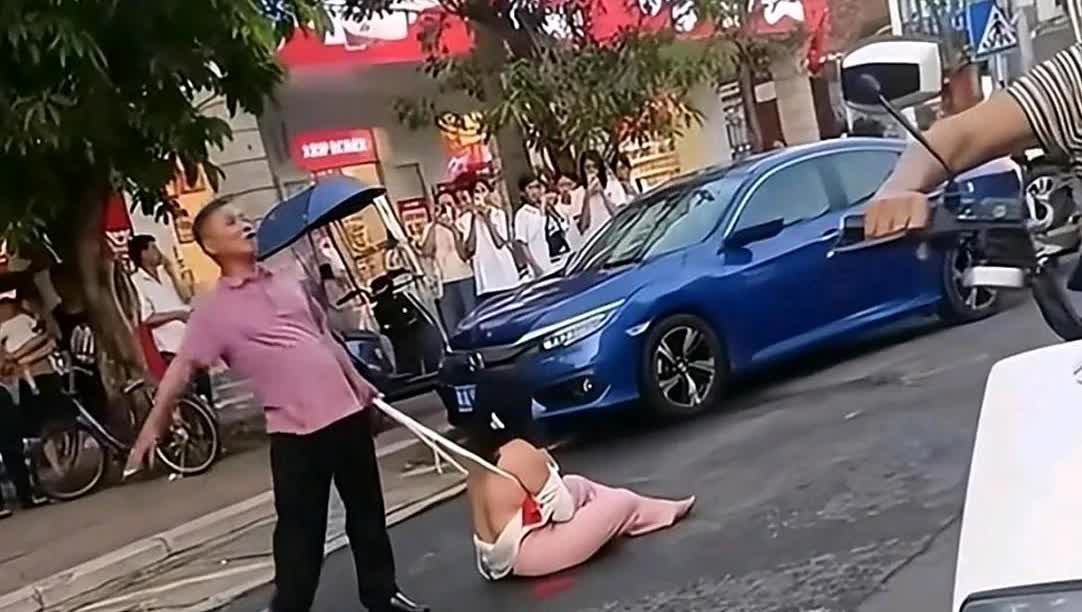 一网友上传:女子出轨被游街侮辱，坐在地上衣衫不整，抱着衣服守护最后的尊严！