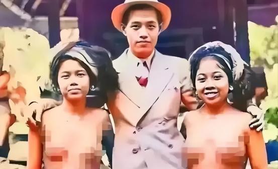 1932年，一名去巴厘岛游玩的男子，搂着两名原住民美女拍照。两位美女笑得非常自然