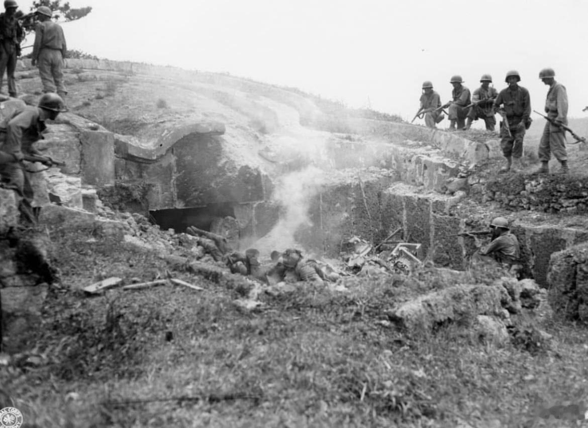 1945年5月，第27步兵师的士兵们组成一个团队，掩护一名士兵将手榴弹