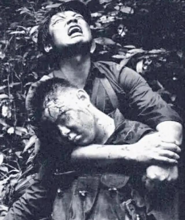 1984年，对越自卫反击战的211高地上，一名士兵头部中弹牺牲，他的战友抱着他的