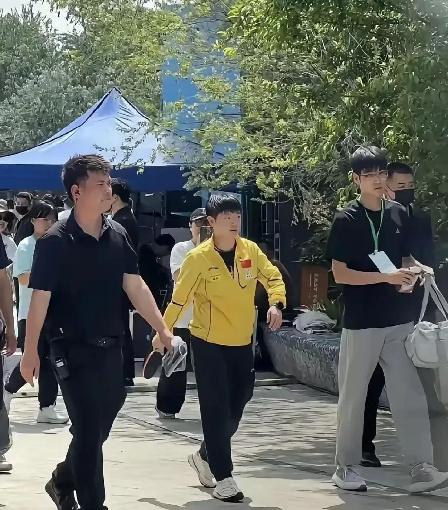莎莎又穿美团黄运动服在人群中是相当惹眼活动结束后手拿着球拍大步流星的气