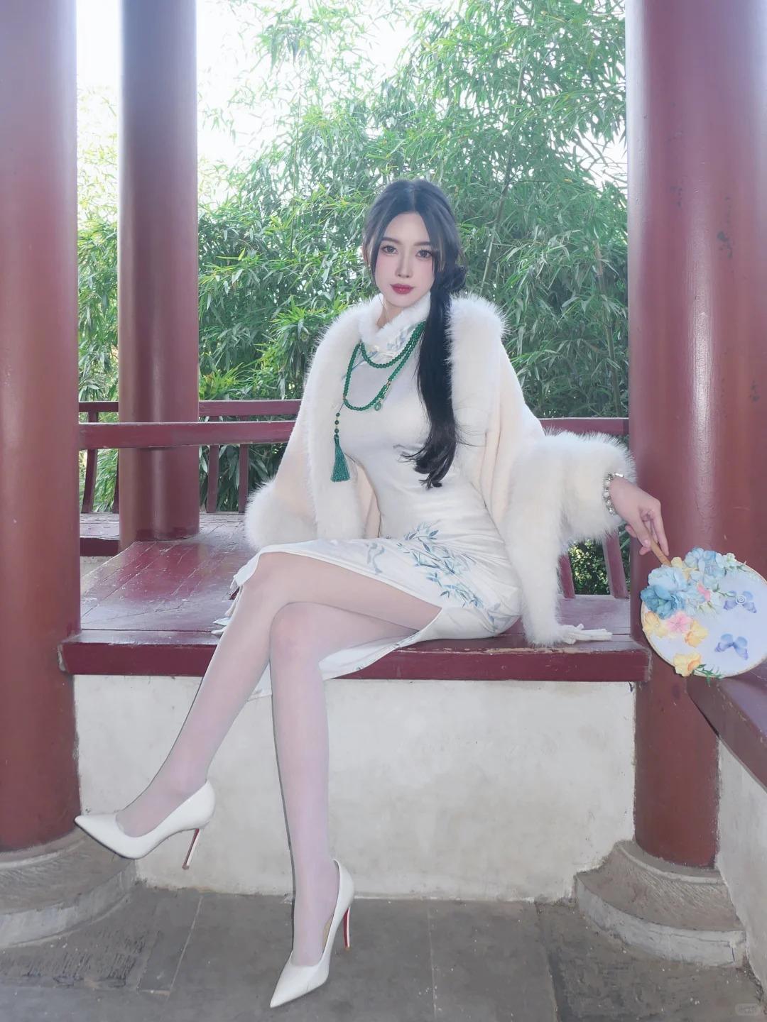 白色旗袍印着淡墨竹纹，清隽雅致藏着东方韵味，柔滑面料衬得身姿愈发温婉。外搭软糯毛