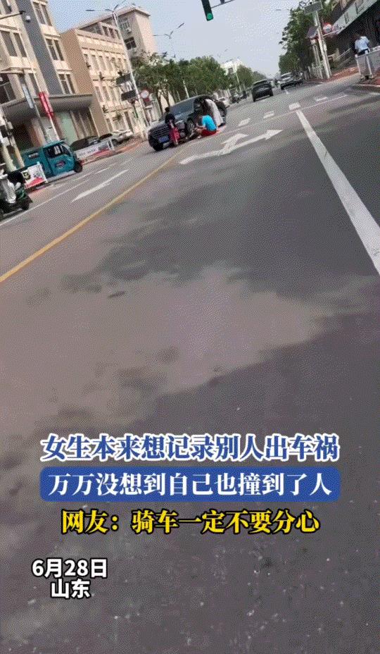 哭笑不得。山东，一女子骑着电动车行驶在路上时，遇到路边的一起车祸，于是女子则拿出