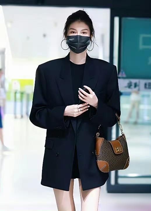 何穗生完孩子后状态更好了！她穿了一身黑色宽松西装，大秀美腿。垫肩设计显得