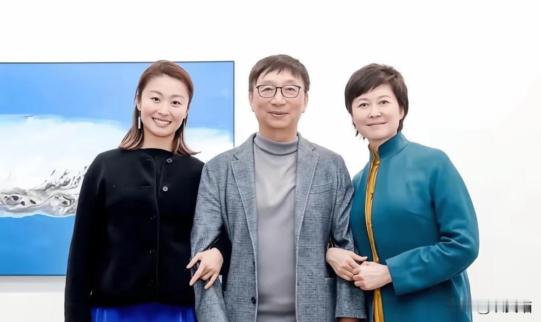 敬一丹挽着丈夫的手臂，女儿站在旁边，这张2023年的合影里，背景那幅《天堂湖