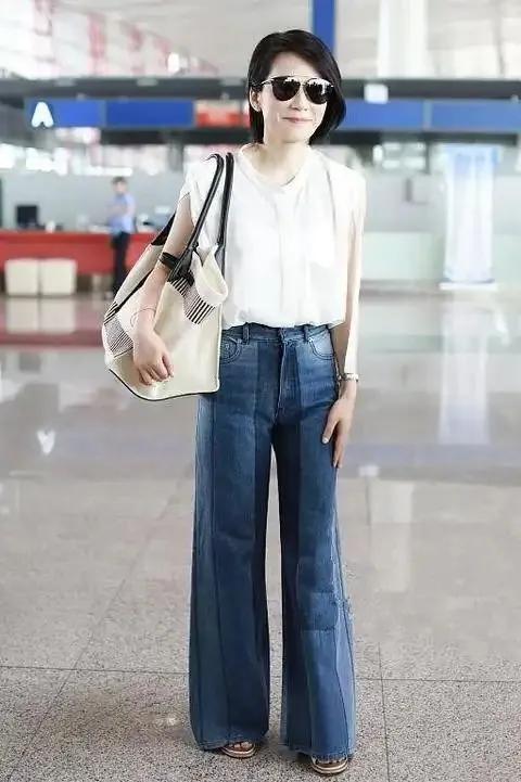 俞飞鸿这机场穿搭，是把“舒服又高级”焊在身上了！白色无袖上衣软乎乎的，喇叭