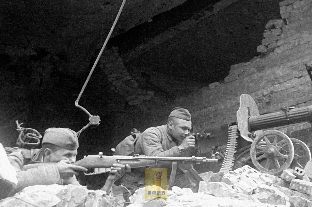 1945年，柏林。巷战中，苏军战士在废墟堆上操作“马克沁”机枪向敌人射击。“马克