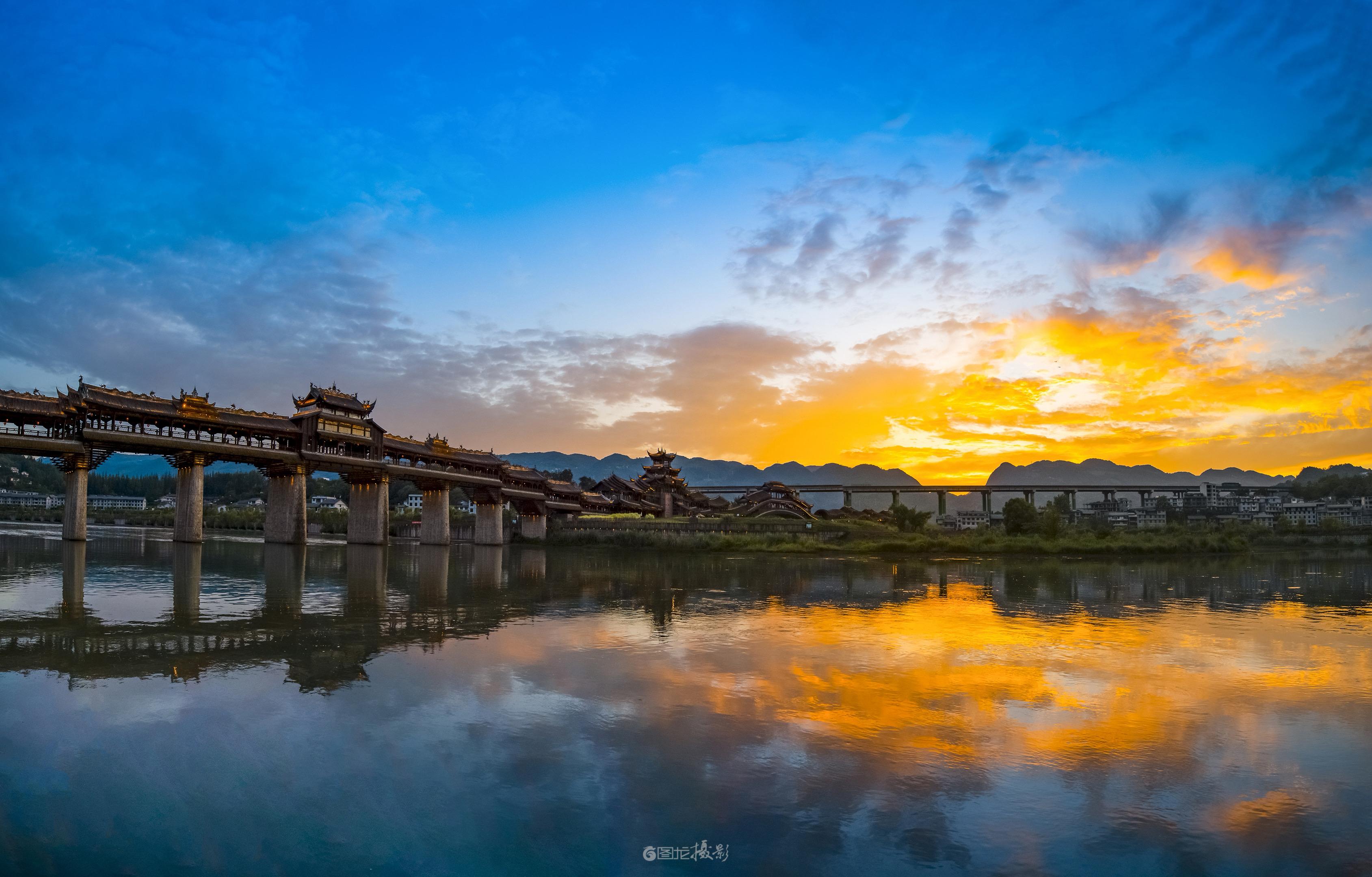 濯水古镇的夕阳：廊桥与晚霞的千年对话。当夕阳把阿蓬江酿成一坛金红的酒...