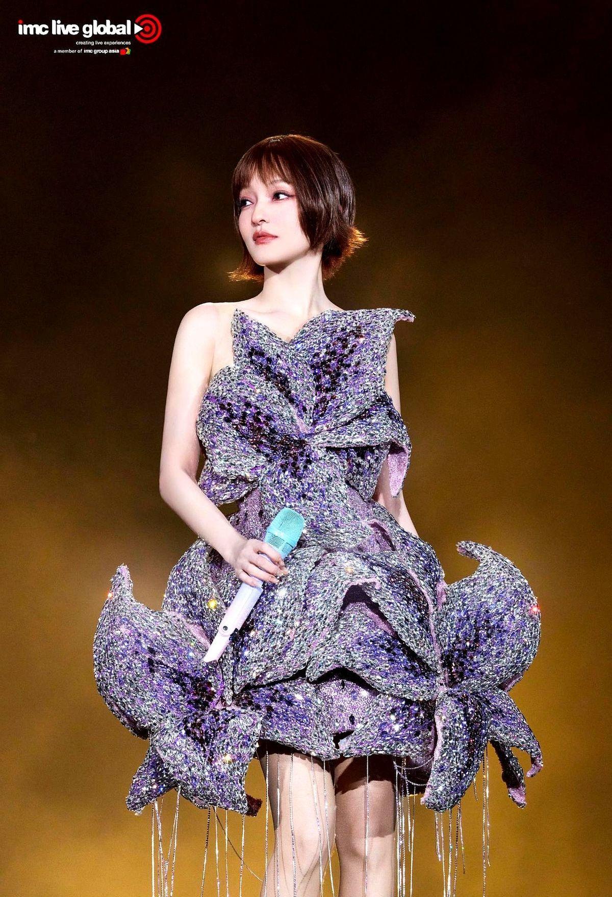 金属花瓣裹身的战袍。亮钻闪得晃眼。头发却像刚洗完没吹。裙摆扫过红毯时，每片