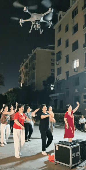 突降“暴雨”？一群大妈在小区楼下跳广场舞，无人机向人群洒水，大妈慌着收场。可