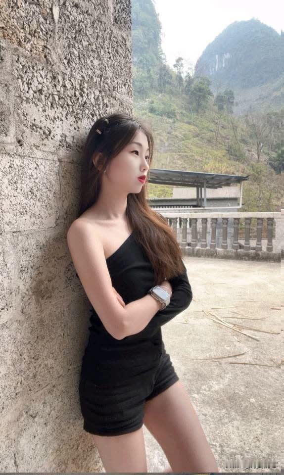 山间少女，黑裙轻倚，静享自然之美。