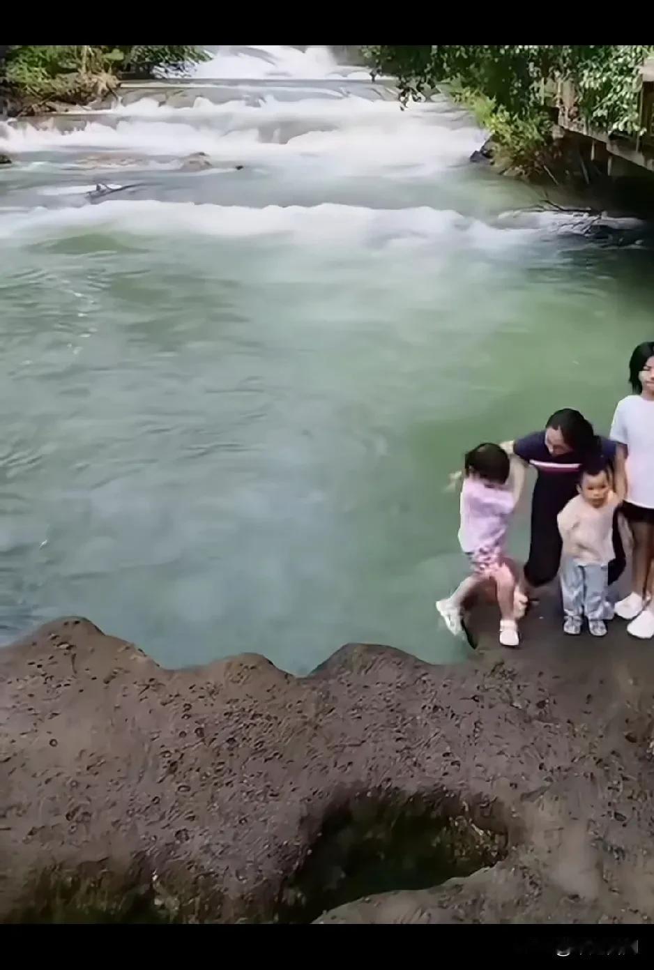 就为了一家人在急流水附近拍照，妈妈不小心把小女孩碰到河里，妈妈来回走动，10秒钟