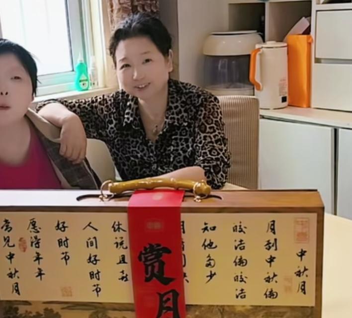 杜大娘今天收到了月饼！明天是中秋节，杜大娘更新了作品，大娘母女俩坐在桌子边，