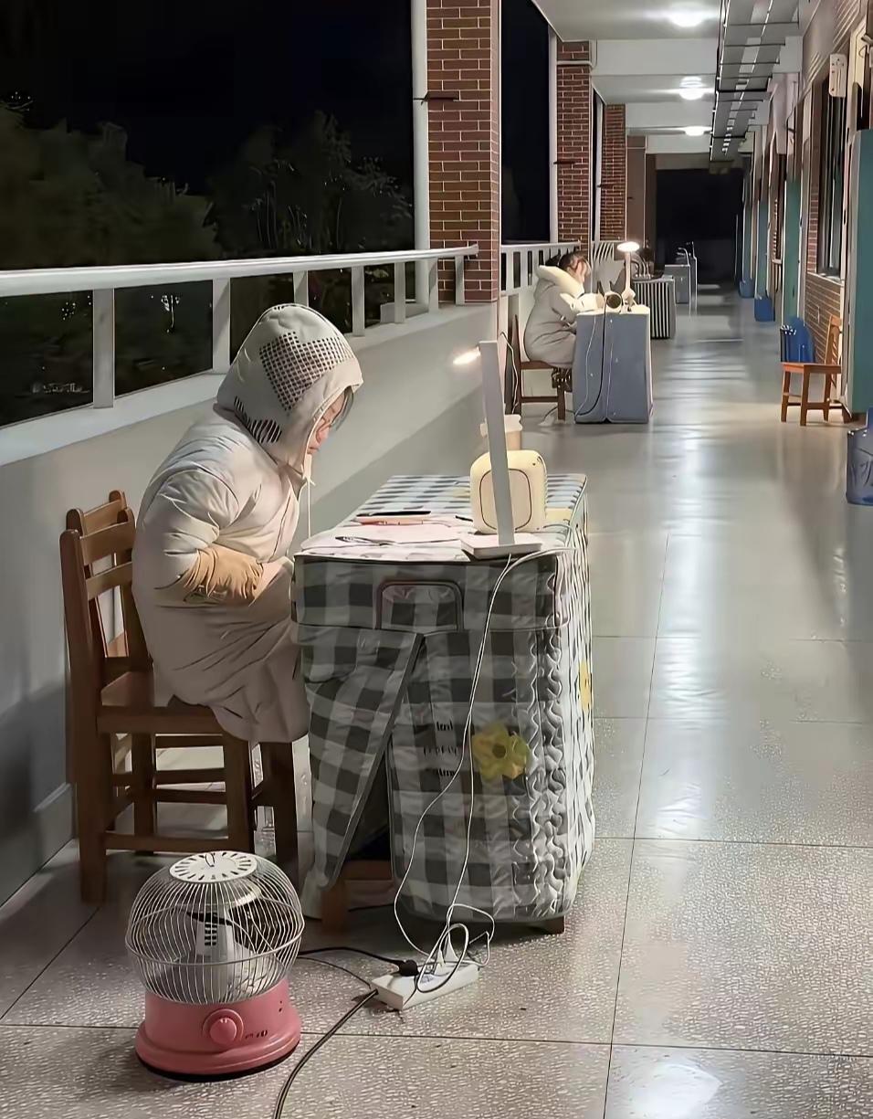 高中教师在寒风中瑟瑟发抖办公，这是教学楼走廊办公，为了方便学生解疑问答，这校长还