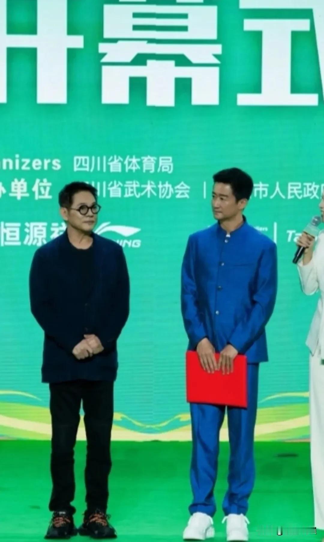李连杰和吴京，两大功夫明星现身四川峨眉山体育馆参加活动。李连杰戴着眼镜，穿着西
