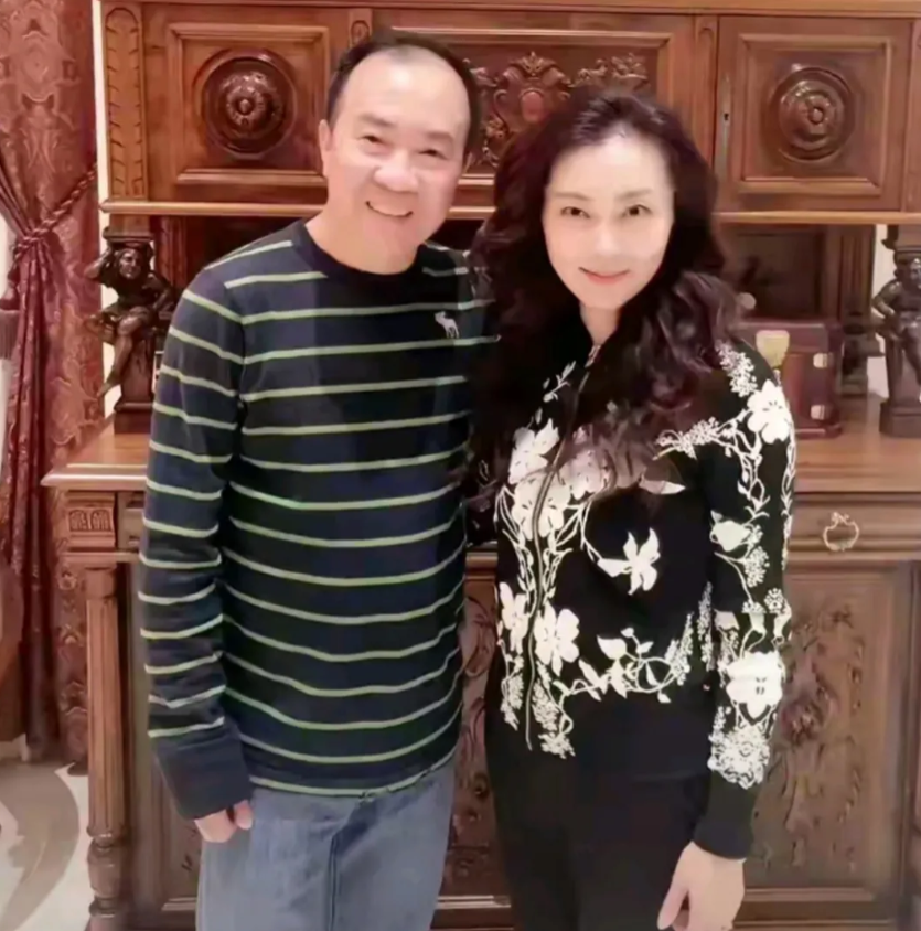 画面中62岁的戴志诚虽已谢顶，但依旧胖瘦合度，气色盈和，笑容可掬；一旁的妻子袁茵
