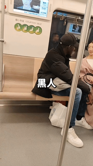地铁上拍到一名黑人男子正在和两名年轻女孩聊天说话。这个黑哥中文说的非常流利，甚