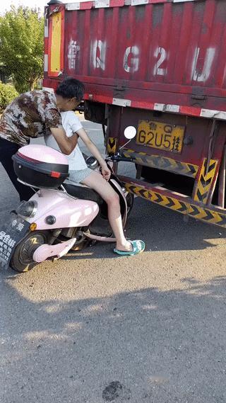 一名年轻女孩在马路上骑车意外追尾大货车，受伤之后当场昏迷！一位大爷见状赶忙走过