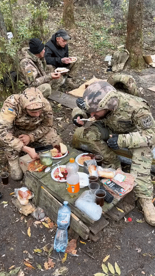 乌军指挥官和士兵正在战场上吃饭。看他们吃的东西有牛肉荞麦焖饭还有果汁饮料？能