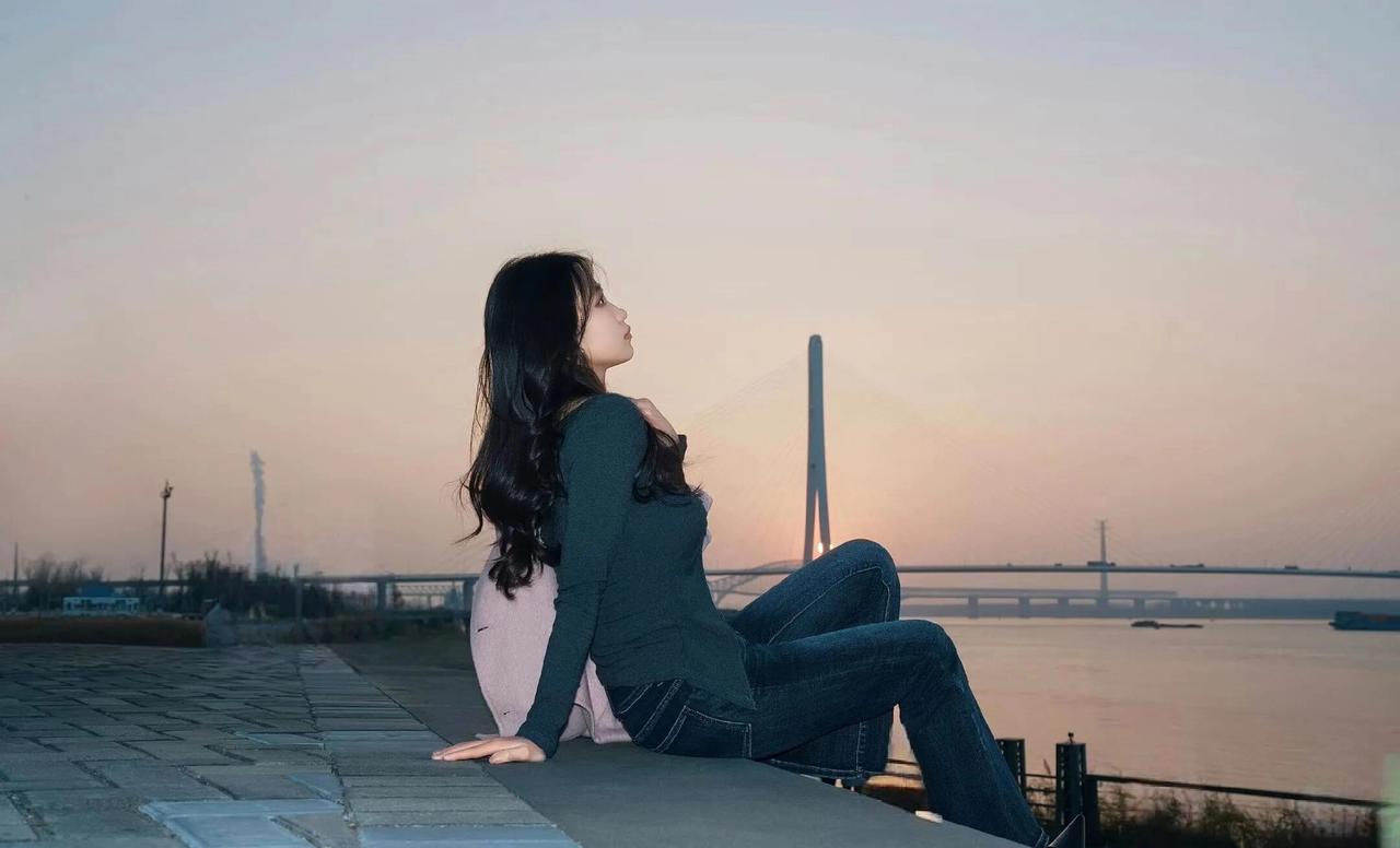 夕阳下的静谧时光，独自坐在桥边，享受宁静与自由。气质型美女