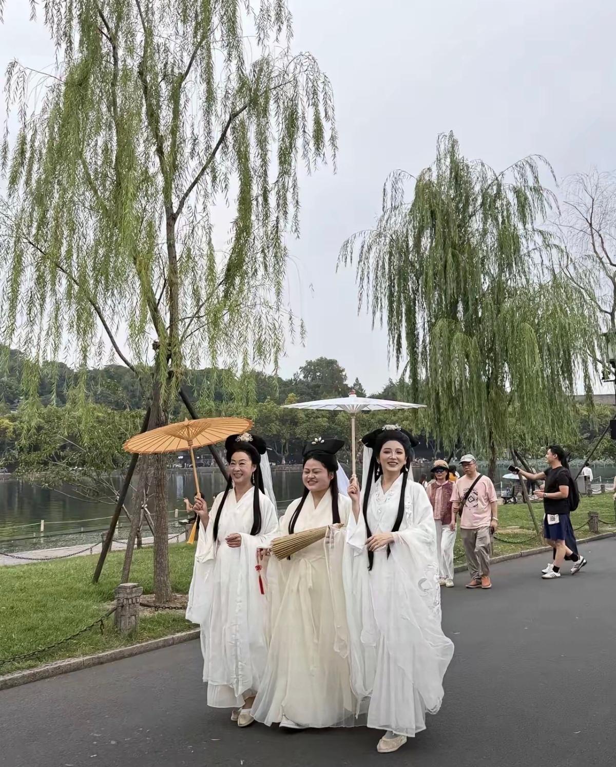 三位白娘子撑伞散步在公园，高下立判。