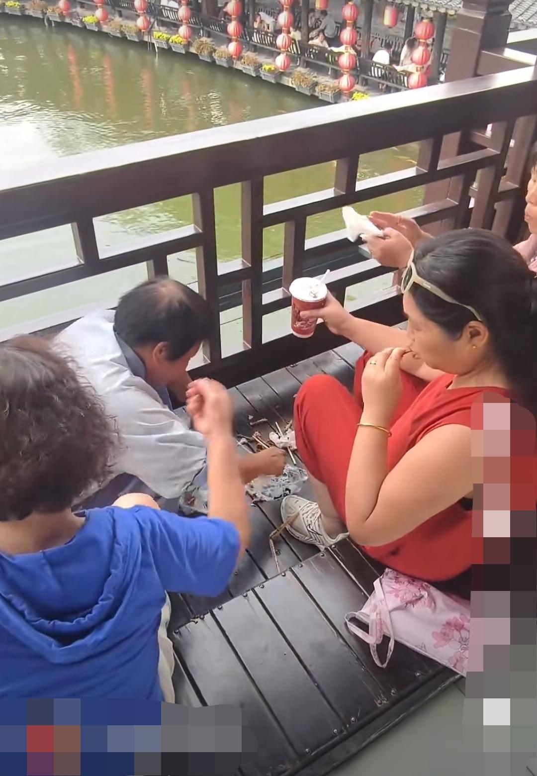 河南开封某景区内，几名大妈坐在椅子上吃东西喝水，随手把垃圾扔得满地都是。景区工作