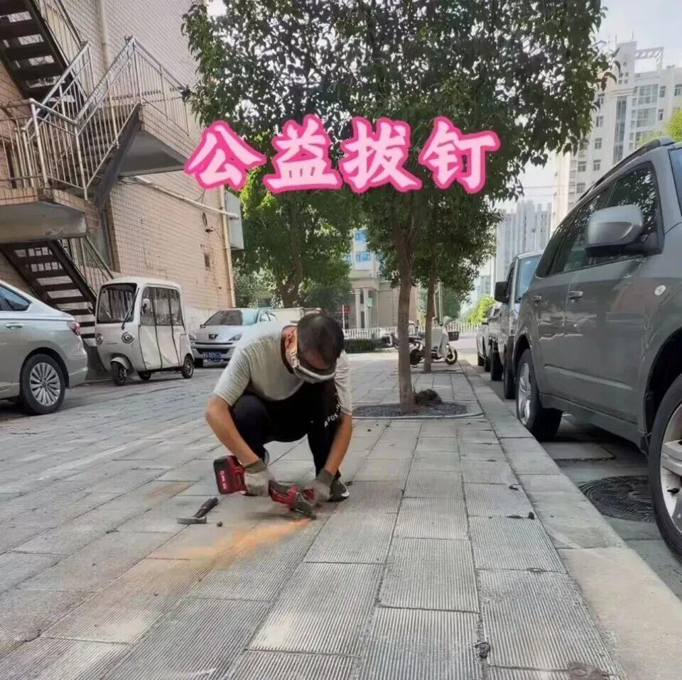 新乡拔钉侠自费清理路面伤人地钉，作业几分钟因扬尘问题被叫停，备案争议引全网热议，