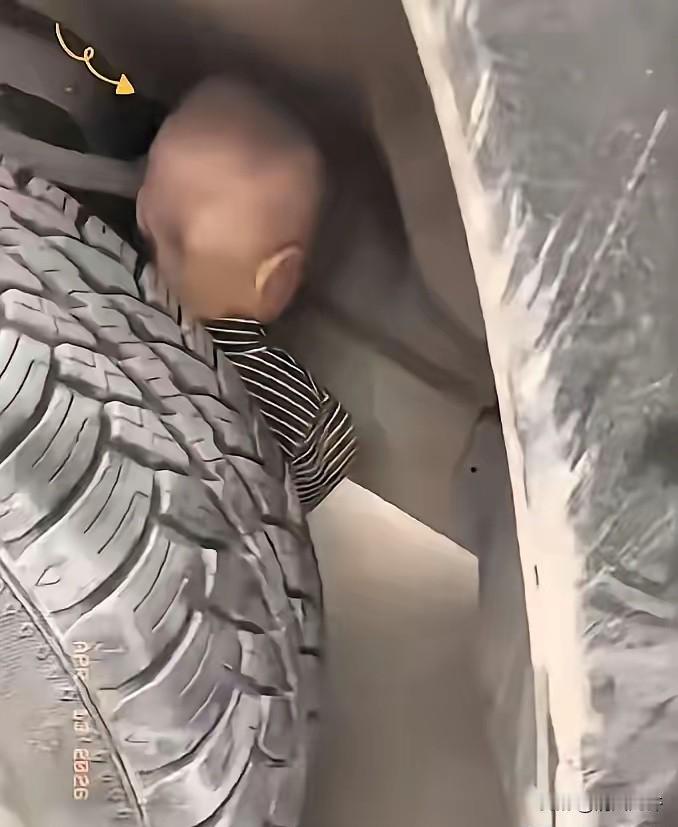 云南昆明一位老司机出车前照例绕车检查，却没想到在轮胎内侧瞅见个四五岁的小娃正蹲着