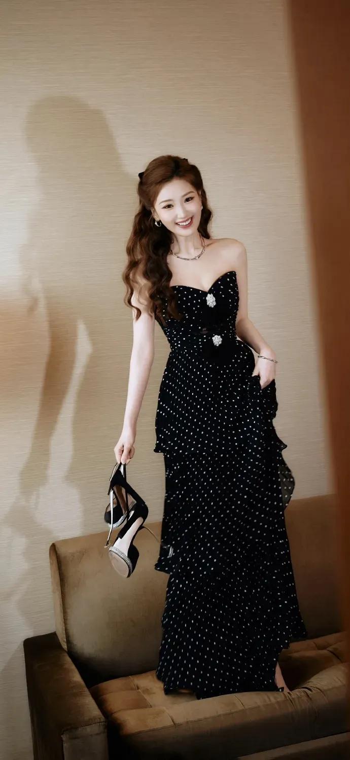 毛晓彤，复古黑底波点抹胸裙勾勒出曼妙身姿，缎面蝴蝶结为卷发添了几分灵动娇俏，细碎