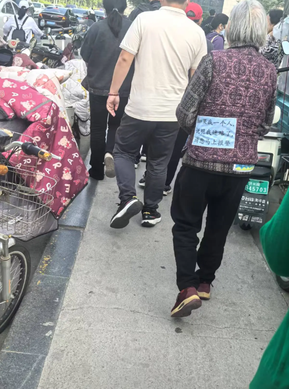 今早上班路上在省中医门口看到的一幕：一位老人衣服上缝上了一块儿布条，上面写着“如