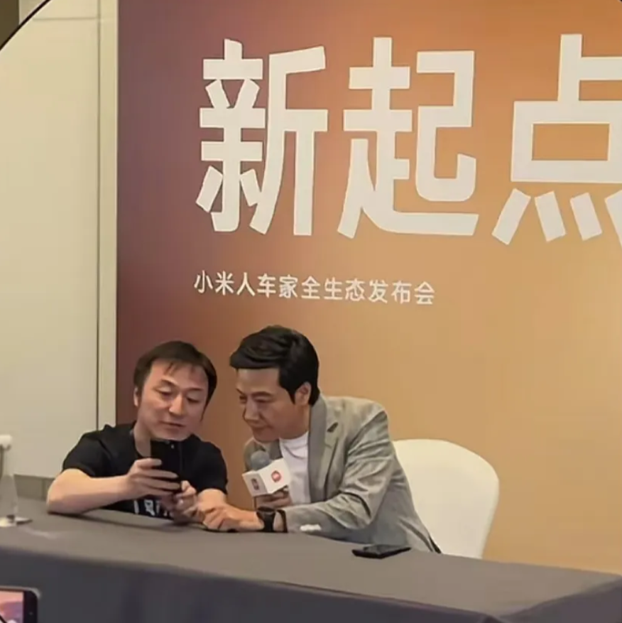 坐在雷军旁边，给雷军看手机的这个人叫徐洁云，是小米目前政府事物的一号人物，也是雷
