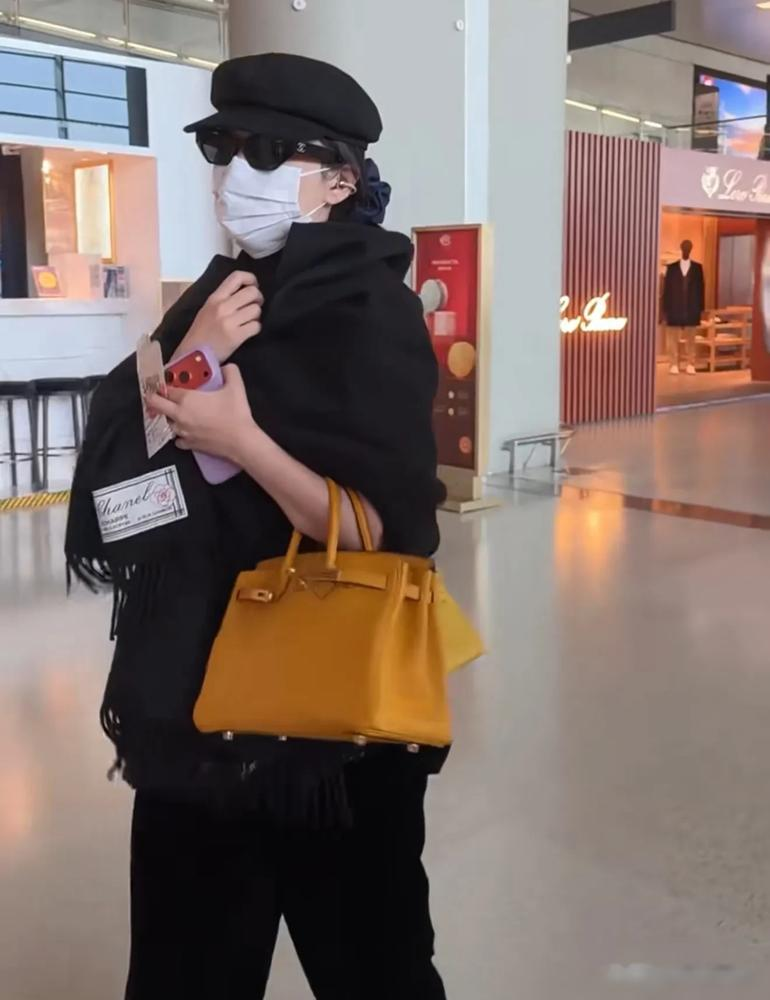 阚清子赶个飞机，脖子上挂一个爱马仕，手里还拎一个，跟拎菜篮子去买菜似的。全黑穿搭，香奈儿墨镜，左边一