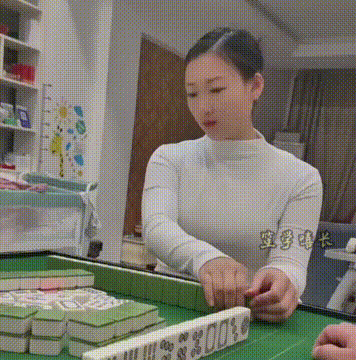 手上动作很熟练，拿起麻将对这里撞两下，美女的反应亮了！