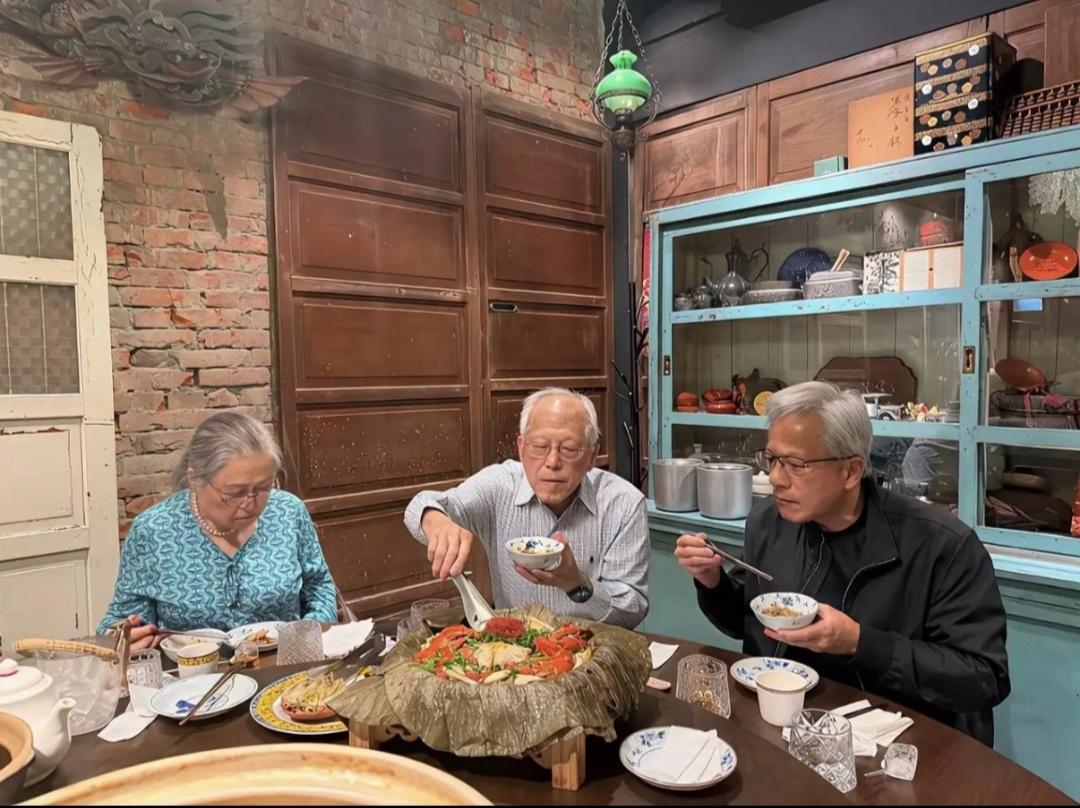 这是黄仁勋回台湾与年迈的父母坐在一起吃饭的场景。从图片中来看，黄仁勋的老父亲正在