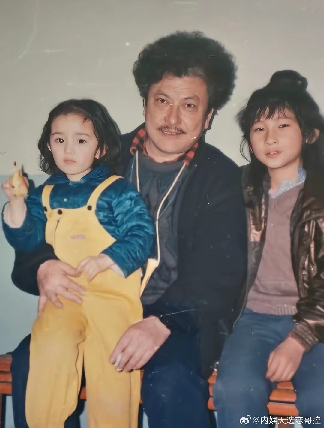 杨幂小时候的样子实在太招人喜欢了一头微卷的头发扎着双马尾黄色背带裤好时尚一看就是