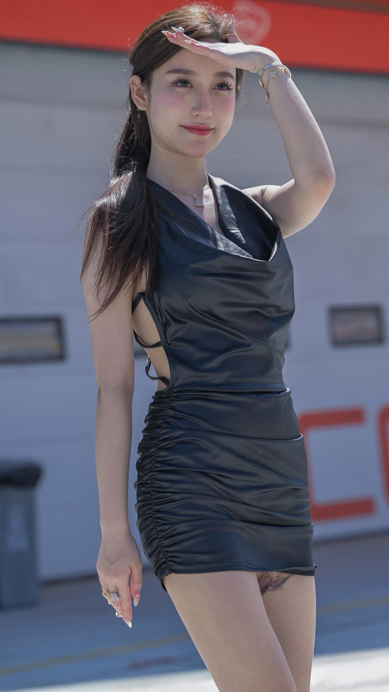 一袭质感十足的黑色礼裙，勾勒出曼妙身姿，露背设计与褶皱细节尽显摩登风情。