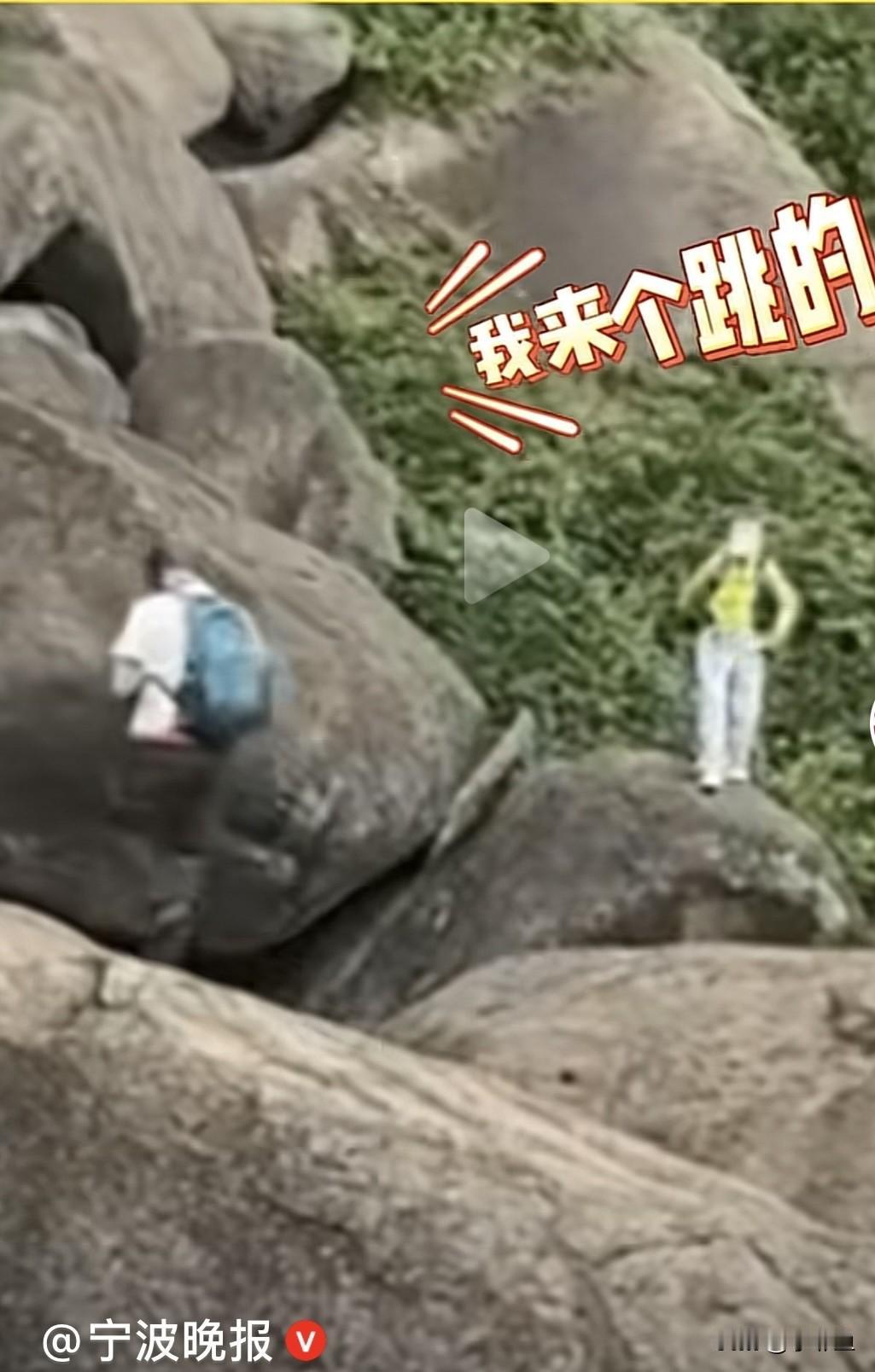 近日，江西一旅游景点，游客们在山上，一女子站在石头上向同伴喊道我来个跳的，说完就