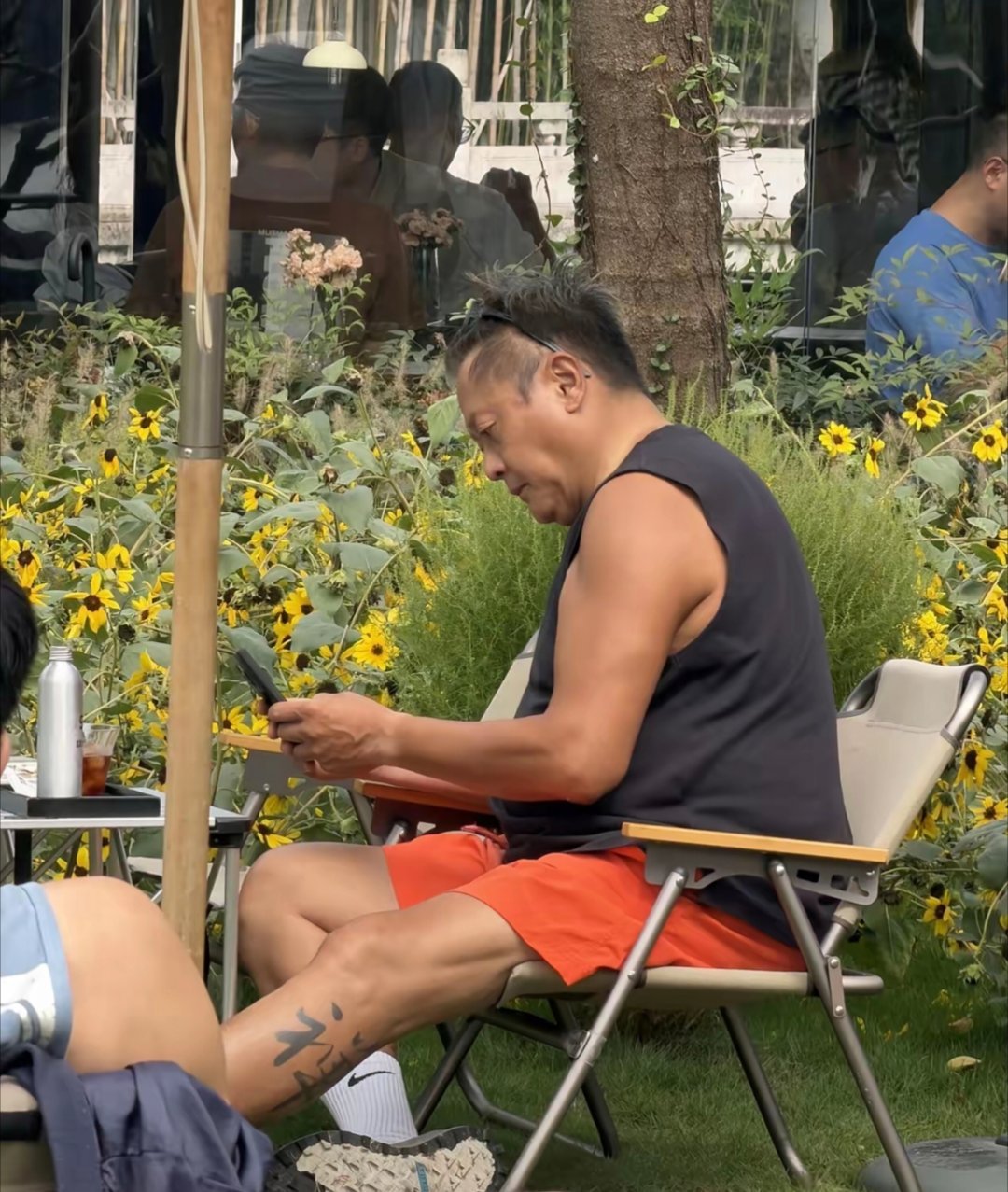 59岁香港男星魏骏杰在杭州湘湖边喝咖啡，皮肤黝黑，身材肥胖，整个人形象大变样，一