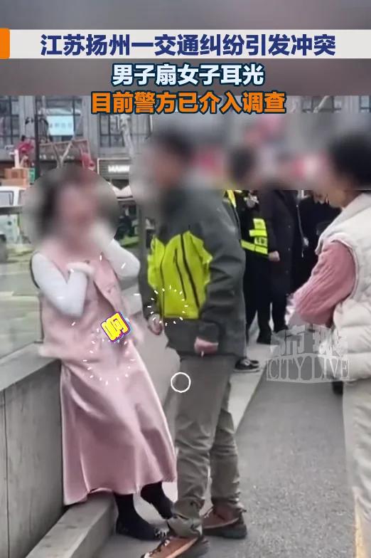 江苏扬州。小仙女驾车堵路引发阻塞，拒绝挪车，男子下车理论，辅警前来调停，男子扇