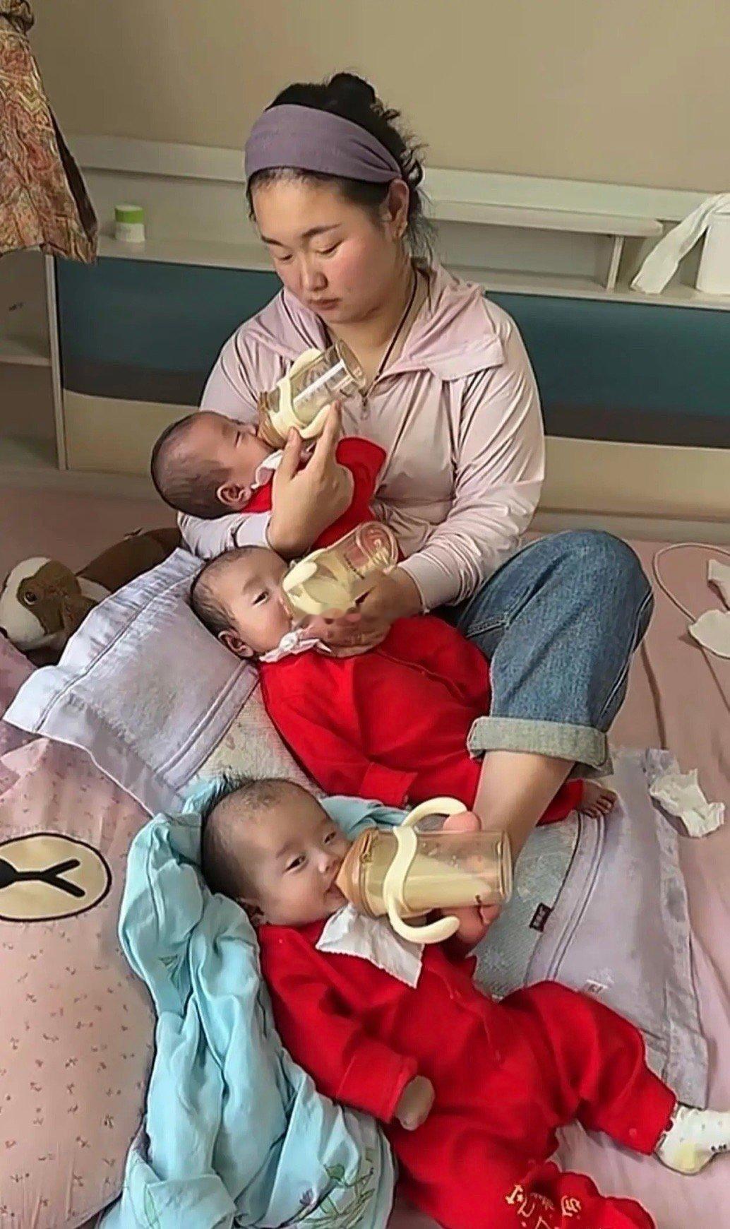 办法总比困难多。一个妈妈三个儿，还没个帮手，只能自己同时给三孩子喂奶，现在是苦一