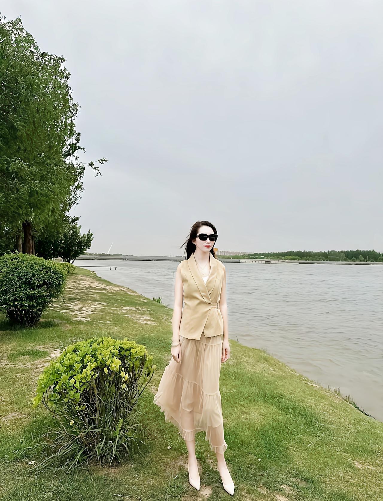 夏日河畔漫步，轻纱飘逸，墨镜遮面，享受宁静时光。