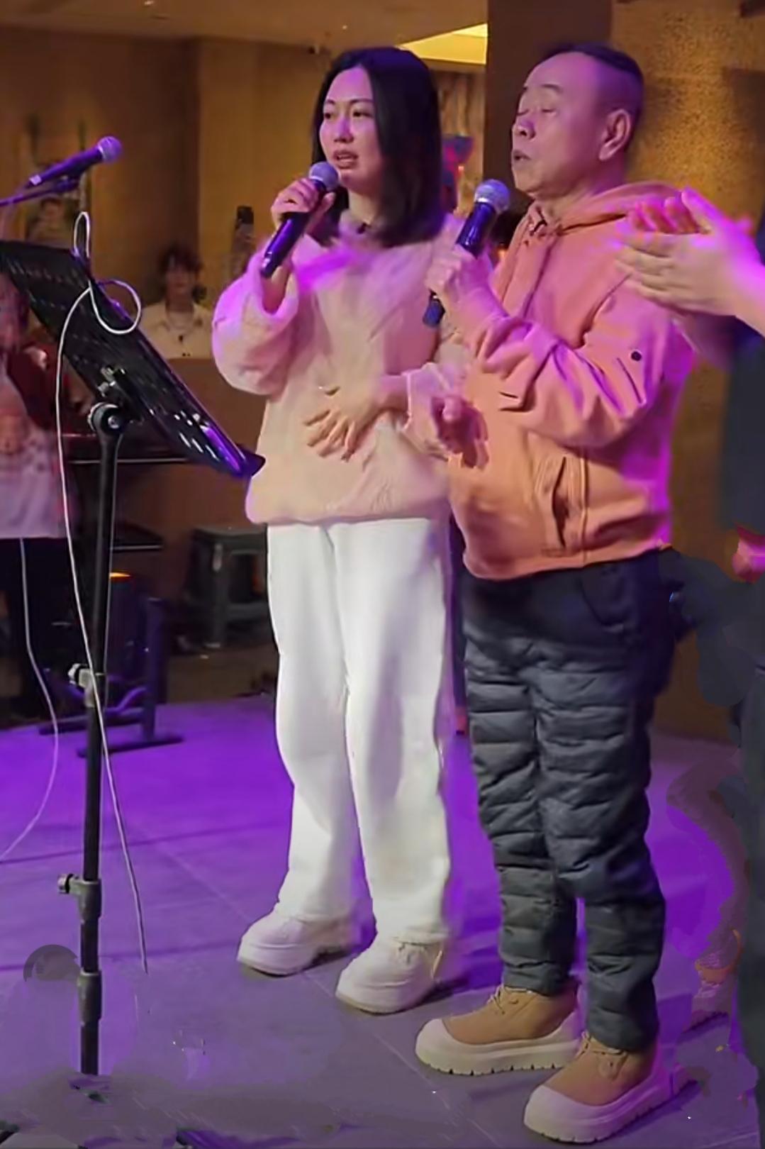 潘长江老师和女儿潘阳现身沈阳中街，潘长江穿着蓝色羽绒裤，粉色连帽卫衣，头戴灰色毛