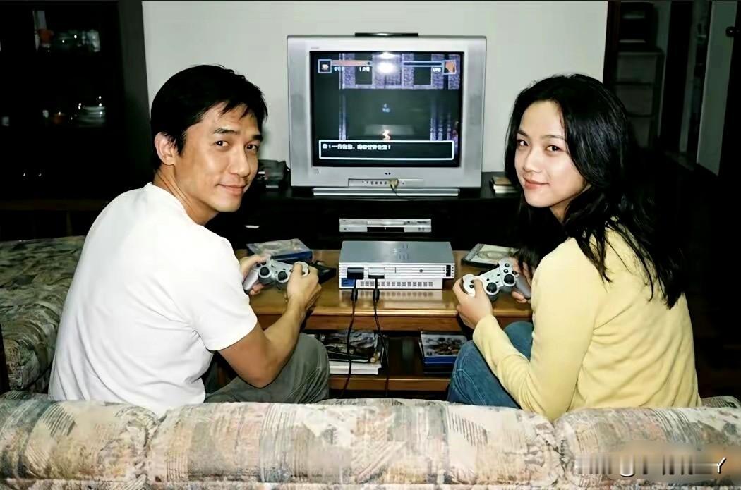 这张照片展现出了汤唯和梁朝伟2007年在室内坐在沙发上打游戏时的情景，彼时汤唯2