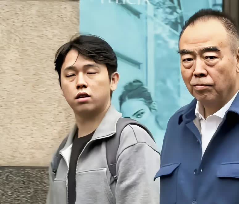 陈凯歌和大儿子陈雨昂在上海街头漫步，父子俩还真像，尤其嘴巴像，有点凸，脸型和五官