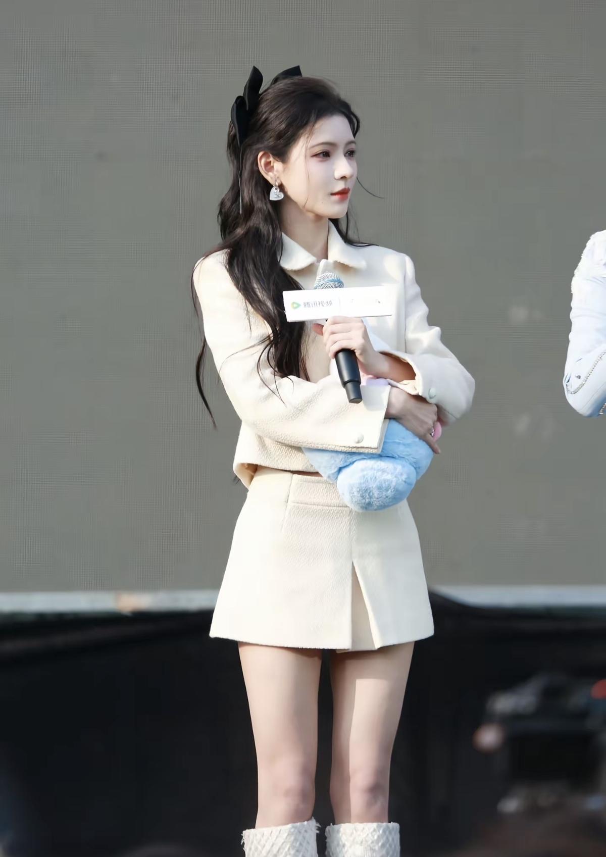 张予曦身穿米白色短款小香风套装（短上衣+高腰短裙）搭配白色长筒靴，既凸显