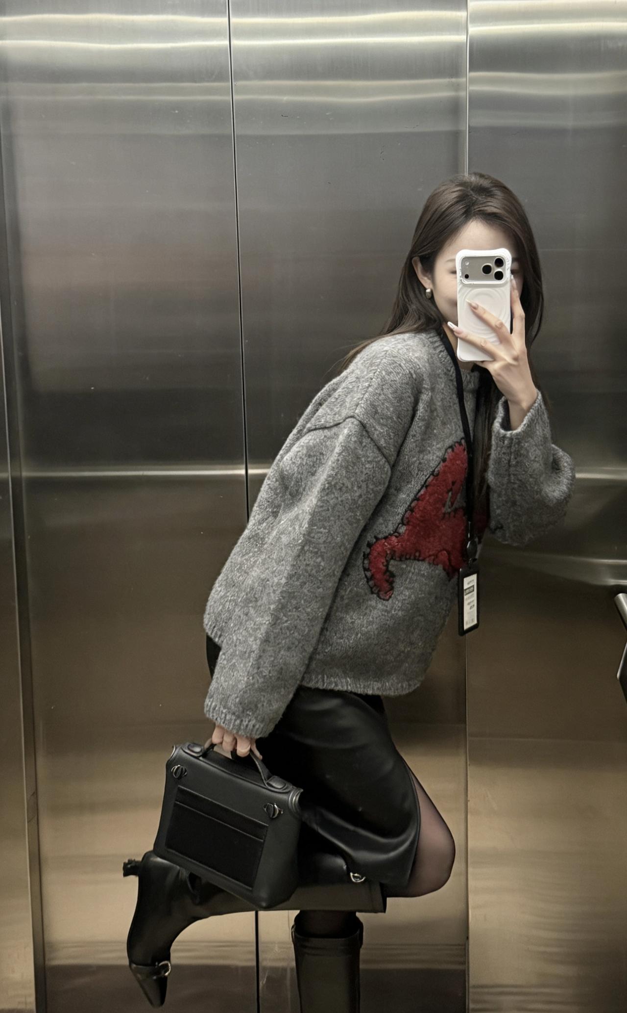 今日穿搭推荐是灰色重工图案毛衣+黑色开叉皮裙+黑色长筒靴的组合。整体风